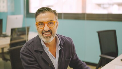 Mature man working in a coworking desk and smiling