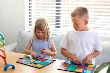Brother and sister are playing educational wooden logic games. The concept of child development 