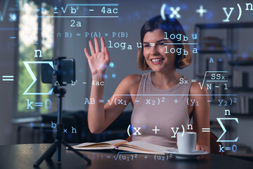 Happy woman is making video blog using smartphone on a tripod explaining with hands at office workplace. Concept of online stream, business education, conference call. Education hologram