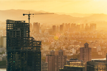 Silhouette of tower crane and skyline of Ningbo City at sunset