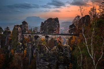 Saxon, Germany - The Bastei bridge with a sunny autumn sunset with colorful foliage and sky. Bastei is famous for the beautiful rock formation in Saxon Switzerland National Park near Dresden