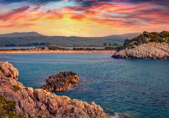 Sunside on rocky coast of Voidokilia Beach. Picturesque summer seascpae of Ionian sea, Pilos town...