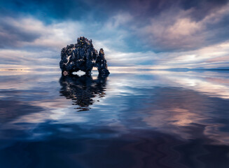 Huge basalt cliff Hvitserkur reflected in the calm waters of Atlantic ocean. Dramatic summer scene...