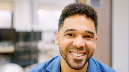 Hispanic man smiling at camera working in a coworking