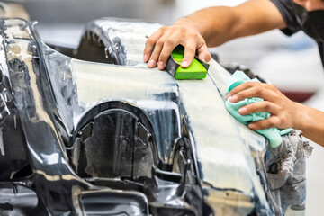 Car polish wax worker hands applying protective tape before polishing. Buffing and polishing car