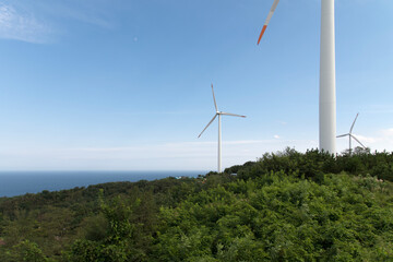 View of the wind turbine on the hill against the sky background