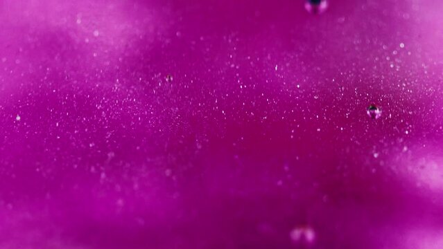 Shimmering gel. Oil bubbles. Defocused neon pink purple transparent smooth glitter substance spill spreading art abstract background.