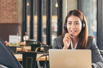 Women helpdesk call center use headphones talk to customer. Asian woman operator assistant customer...