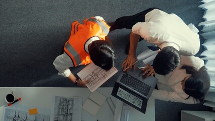 Top down view of project manager and civil engineer hold laptop while explain idea to architect....