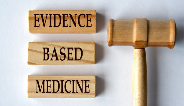 EVIDENCE BASED MEDICINE - words on wooden blocks on a white background with a judge's gavel.