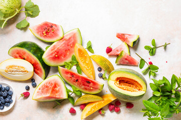 Slices of ripe watermelons, melons and various berries.