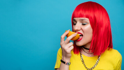 A young beautiful funny model bites off a slice of orange. Healthy vitamin food. Fresh fruit....