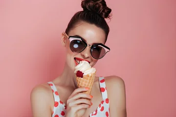 Foto op Canvas Woman in sunglasses eating ice cream. Summer vacation and travel concept. Retro and vintage style. Attractive pinup girl. Design for banner, poster, magazine © dreamdes