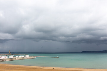 Gulf, port and shore with dramatic cloudy sky
