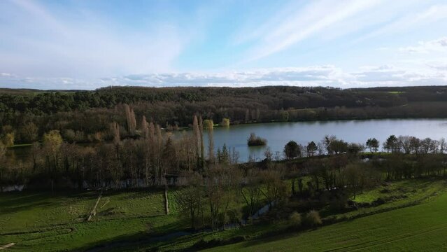 Dampierre sur Avre pond and surrounding rural landscape, France. Aerial drone ascending and sky for copy space