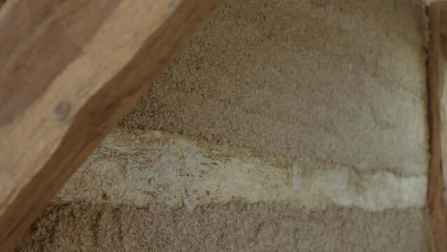 Close-up side pan revealing a hempcrete wall in timber frame during construction