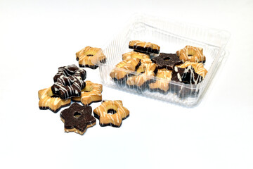 On a white background lie cookies created with the addition of cocoa. Cookies of two colors and...