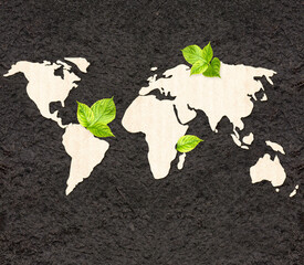 Ecology and zero waste concept. World map silhouette made of  cardboard and green leaves on black soil. Horizontal banner with eco paper texture. Global ecological resource. Copy space for text