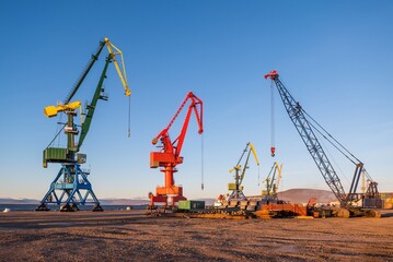 Fototapeta na wymiar harbour cranes at the seaport against a clear blue sky