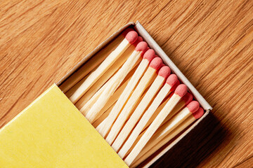 A slightly opened box of matches on a wooden background. Top view.