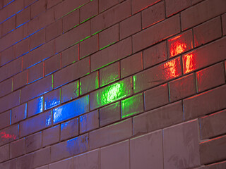 Reflection of colored lights - blue, green, red - on the wall tiles - background