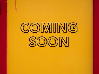 Photography of a sign Coming soon - yellow background and red frames