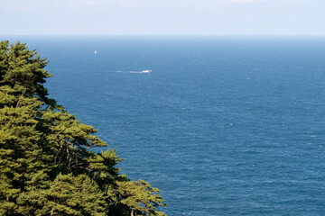 View of a sailing boat by the cliff
