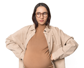 Pregnant young Caucasian woman showcasing maternity on studio background confused, feels doubtful and unsure.