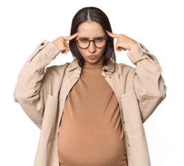 Pregnant young Caucasian woman showcasing maternity on studio background focused on a task, keeping forefingers pointing head.