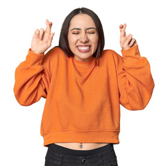 Modern young Caucasian woman portrait on studio background crossing fingers for having luck - obrazy, fototapety, plakaty