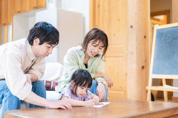Obraz na płótnie Canvas 家でお勉強をする女の子と両親
