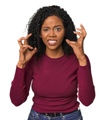 African American woman in studio setting upset screaming with tense hands.