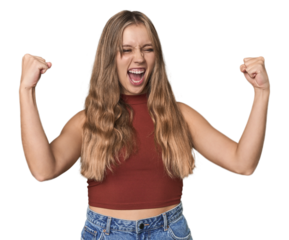 Studio portrait of a blonde Caucasian woman raising fist after a victory, winner concept.