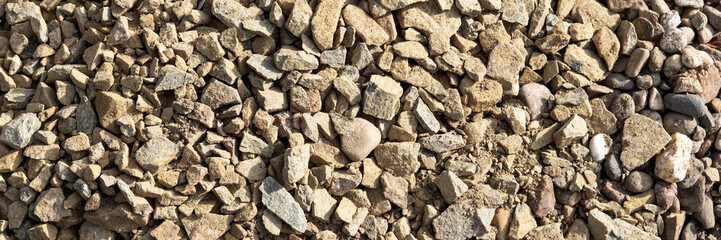 Brown gravel stones for the underground in road construction. Panorama