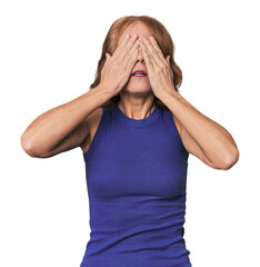 Redhead mid-aged Caucasian woman in studio afraid covering eyes with hands.