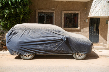 Une voiture sous une bâche dans la ville de Dakar au Sénégal en Afrique de l'Ouest
