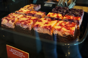 Close up fudge brownie topped with raspberry cheesecake