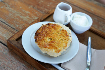 Close up traditional butter scone served with honey syrup and clotted curd cream