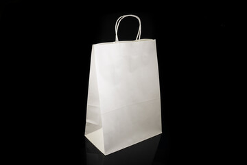 Recyclable craft paper bag for purchases, gifts and takeaway food mock up on black background. Environmentally friendly than single-use plastic bags