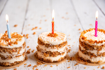 Small cakes with candles on white background