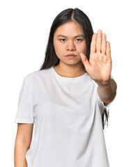 Young chinese woman isolated standing with outstretched hand showing stop sign, preventing you.