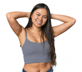 Young Chinese woman in gray top, studio stretching arms, relaxed position.