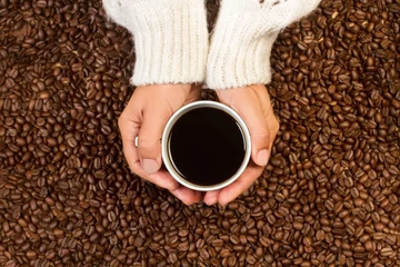 Poster Woman Holding With Both Hands Cup Black Coffee Heap Coffee Grains Top View © Aafiya