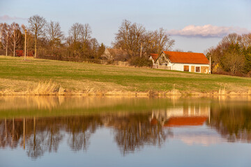 Fototapeta na wymiar Evening over village on a lake bank. Early springtime.