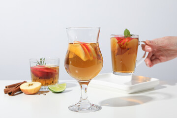 Glasses with apple cider and hand on white background