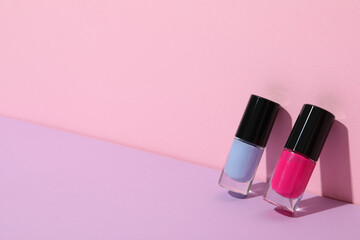 Multicolored nail polishes on a pink background