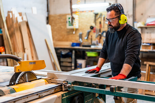 Carpenter cutting aluminum with electric saw