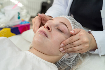 Fototapeta na wymiar female masseur doing felax facial massage at spa. Doctor hands. Pretty female patient