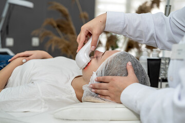 beautician doing cosmetic procedures ultrasonic cavitation facial peeling her female client