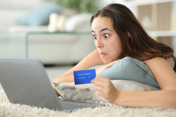 Perplexed online buyer paying with laptop and credit card